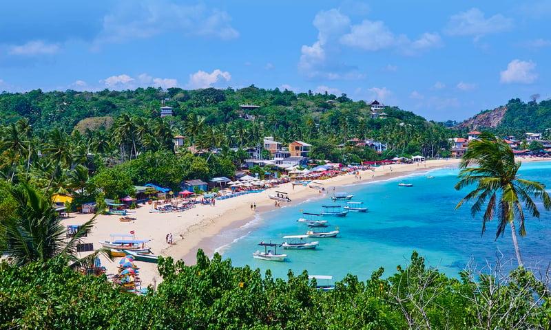 Bãi biển Unawatuna gần Galle nổi bật với bờ cát vàng uốn cong, làn nước xanh trong và khung cảnh nhiệt đới rợp bóng dừa